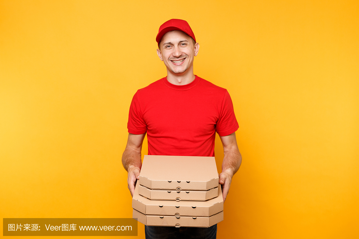 送餐员戴着红帽子,身穿t恤,给外卖披萨盒,黄色背景隔离。男员工披萨工或快递员穿着制服拿着装在纸板箱里的意大利披萨。服务的概念。